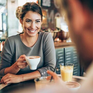 smiling woman if coffee shop showing teeth