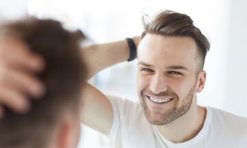 Man with clean teeth smiling in the mirror